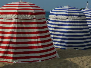 Dicht aneinandergereiht drängen sich die bunt-gestreiften Badezelte am Grande Plage in Biarritz.